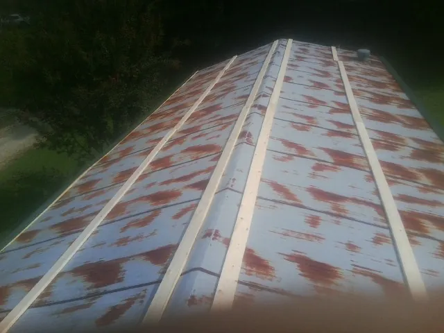 Rusted metal roof panels with new wood purlins before replacement — Storm Damage Roof Repair in Gilmanton Iron Works by Roofing Brothers