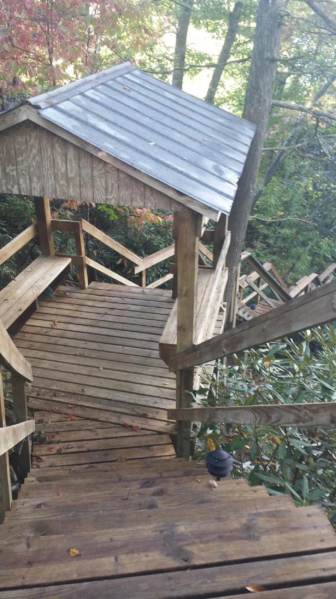 Metal roofed shelter over wooden steps on a wooded walkway — Skylight Repair & Installation work by our crew in Gilmanton Iron Works