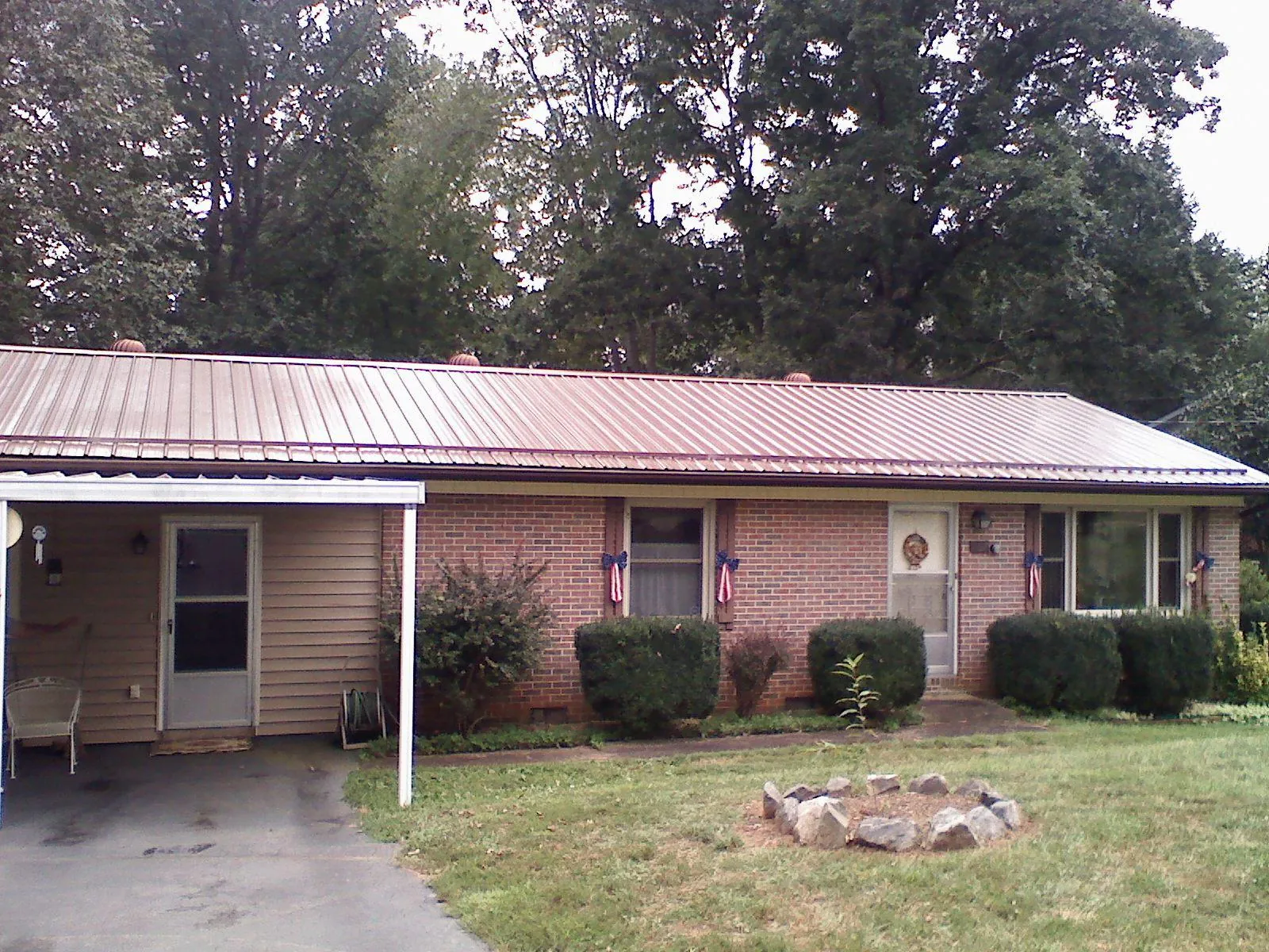 Bronze metal roof and carport on a brick ranch home — Roof Repair work by our crew in Gilmanton Iron Works